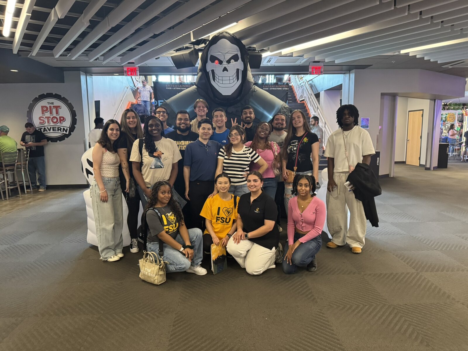 A large group of Framingham State students posing together at an entertainment venue, several in Framingham State shirts